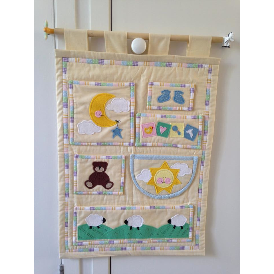 Appliqued and quilted wall hanging with sun,moon and clouds, teddy bear and sheep made by student