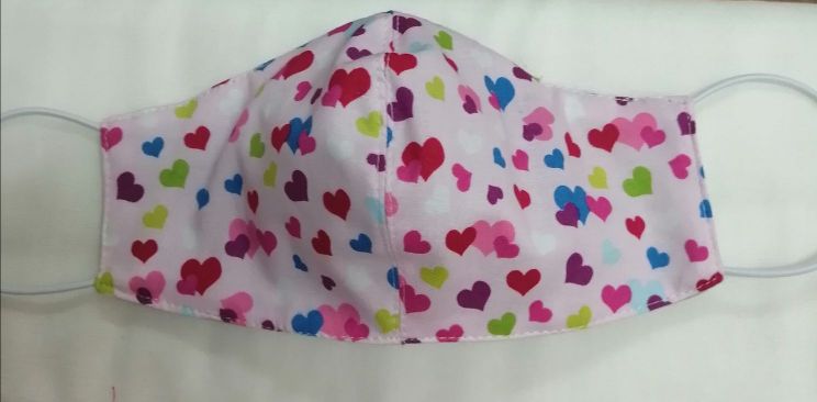 shaped facemask in pink cotton with multicoloured heart shapes